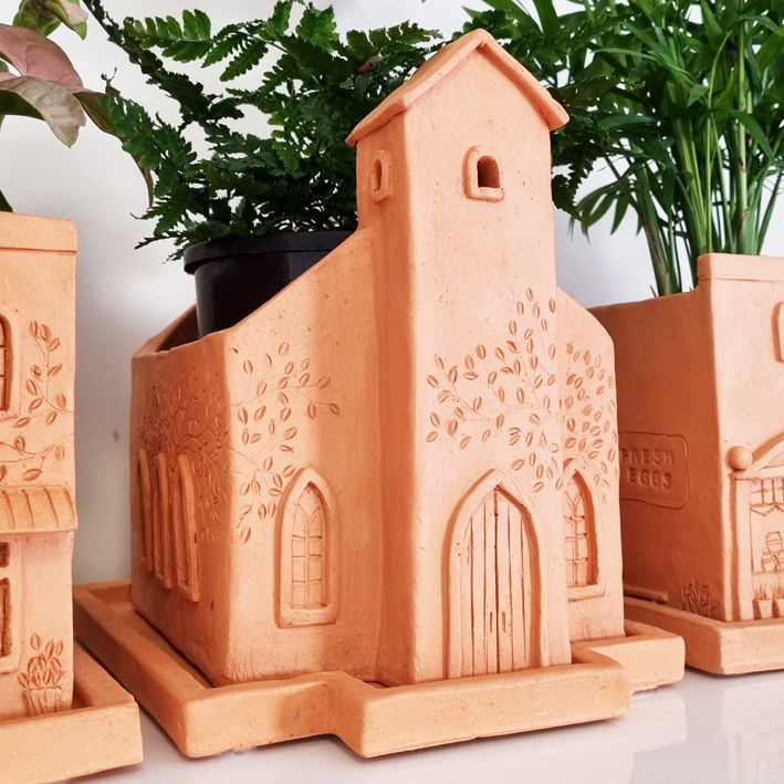 terracotta plant pot shaped like a village church